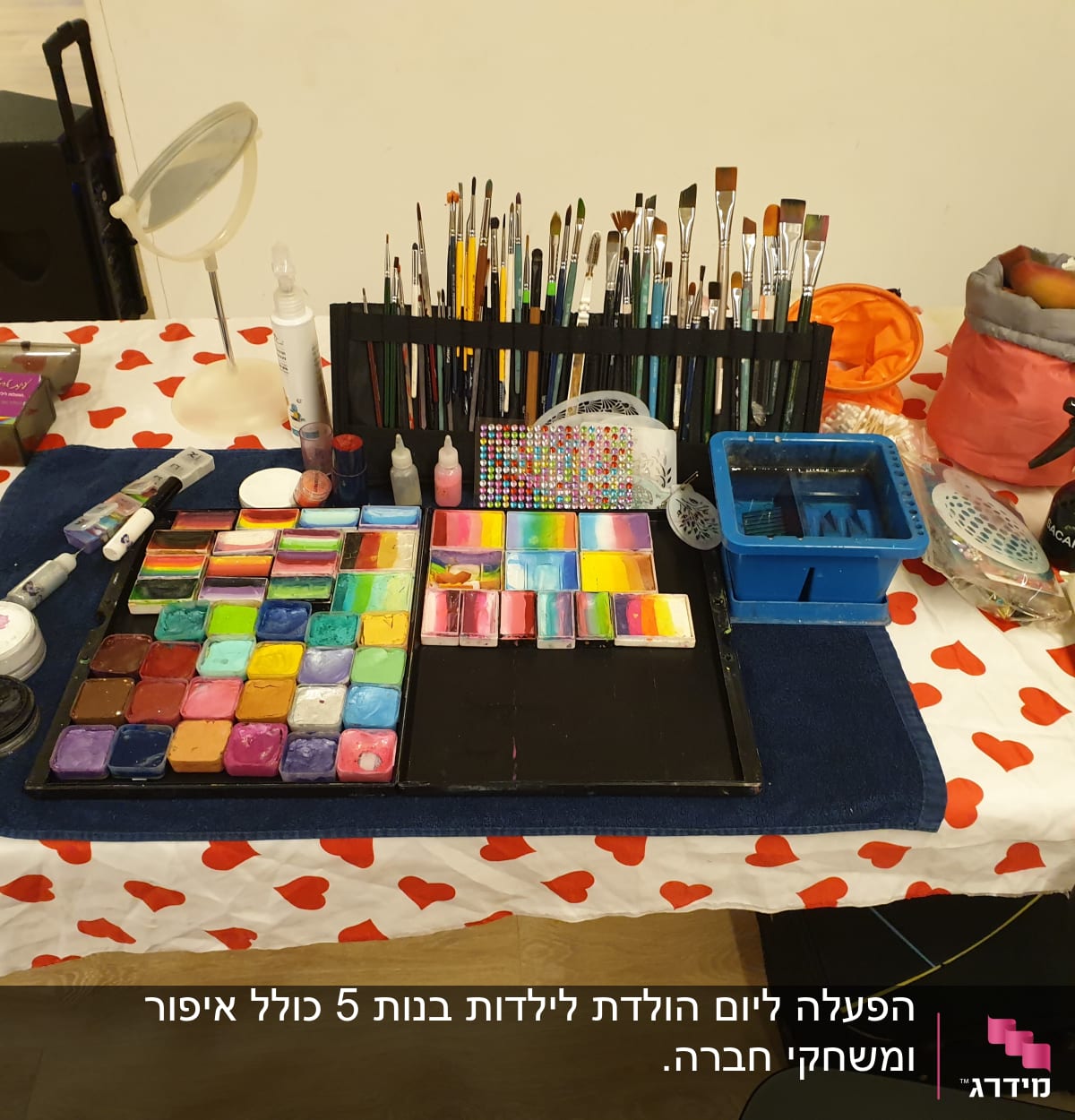 ערכת איפור צבעונית על שולחן עם מפה לבבות